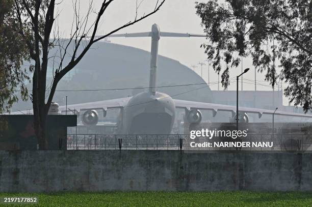 Air Force aircraft carrying Indian migrants deported from the United States, stands on the tarmac after landing at the Guru Ram Das Jee International...