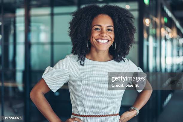 portrait of a smiling black businesswoman - hand on hip stock pictures, royalty-free photos & images