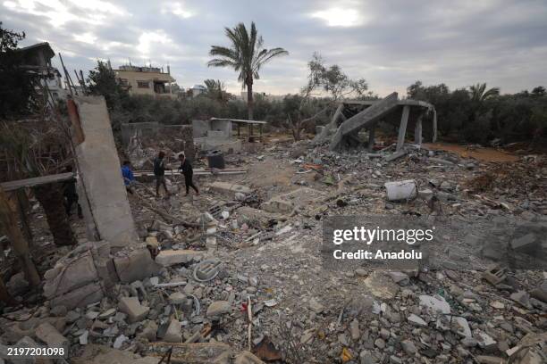 Palestinians work to clear debris in the aftermath of Israeli airstrikes, removing rubble from a destroyed building amid the devastation at Nuseirat...