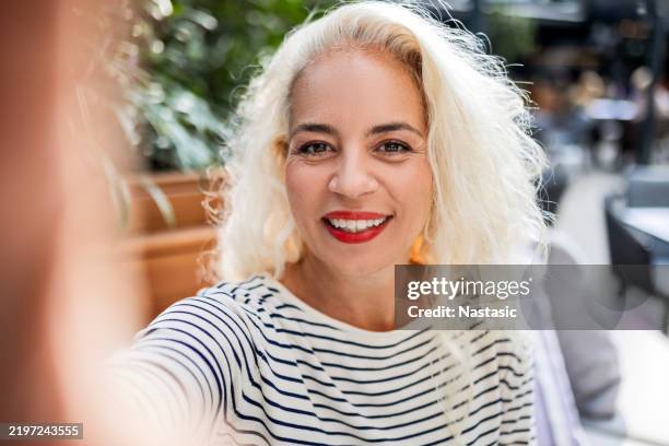 capturing the moment over coffee - mid adult women stock pictures, royalty-free photos & images