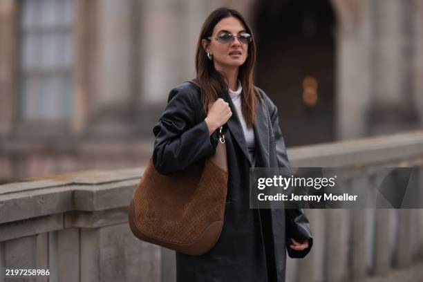 Anna Winter is seen wearing rimless sunglasses with oval grey lenses, a silver metal nose bridge, and transparent temples with silver logo detail...