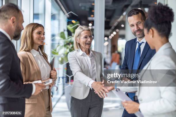 gruppe von geschäftsleuten, die sich partnerschaftlich die hände schütteln - nominierung stock-fotos und bilder