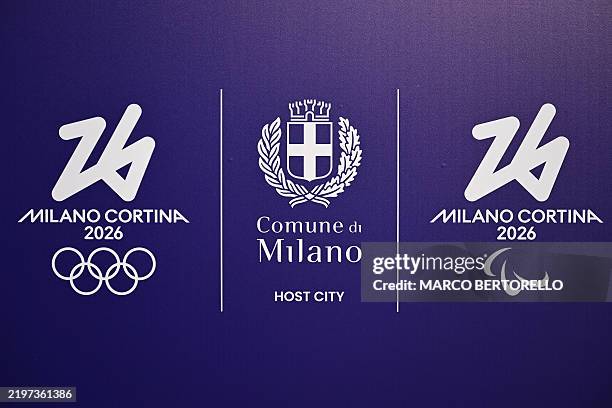 This photograph shows a board bearing the logo of the Winter Olympic and Paralympic Games "Milano Cortina 2026" with the coat of arms of Milan , in...