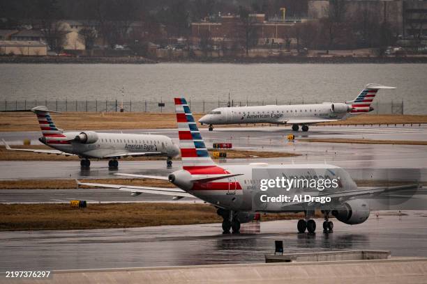 American Eagle and American Airlines planes taxi on the runway at Ronald Reagan National Airport, on February 6, 2025 in Arlington, Virginia. An...