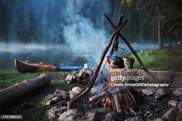 nostalgic camping moment: a vintage teapot by the lake. - camp fire stock pictures, royalty-free photos & images