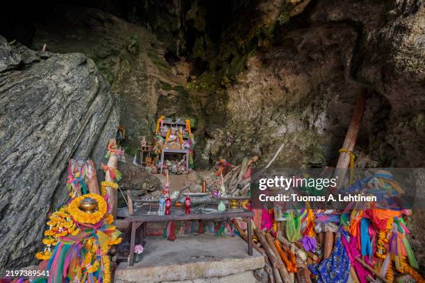 many decorative wooden lingams (phallic symbols) as offerings at a shrine on the phranang (phra nang) beach in railay, krabi, thailand. - limestone stock pictures, royalty-free photos & images