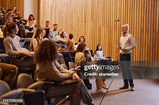 Mature professor talking on a class at lecture hall. Mature professor talking on a class at lecture hall.