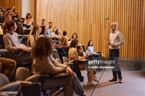 mature professor talking on a class at lecture hall. - sala de aula de universidade imagens e fotografias de stock