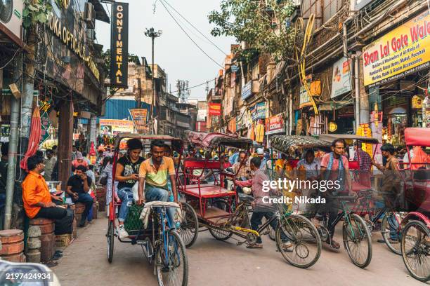 bustling chandni chowk market scene with rickshaws and shoppers in old delhi - delhi stock pictures, royalty-free photos & images