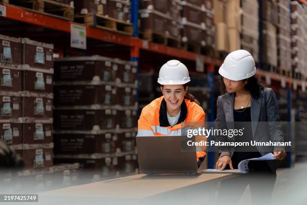 diverse warehouse team analyzing stock data on a digital tablet. african manager and middle eastern employee collaborate on inventory management, logistics planning, and operational efficiency in a modern distribution center. - environmental audit stock pictures, royalty-free photos & images