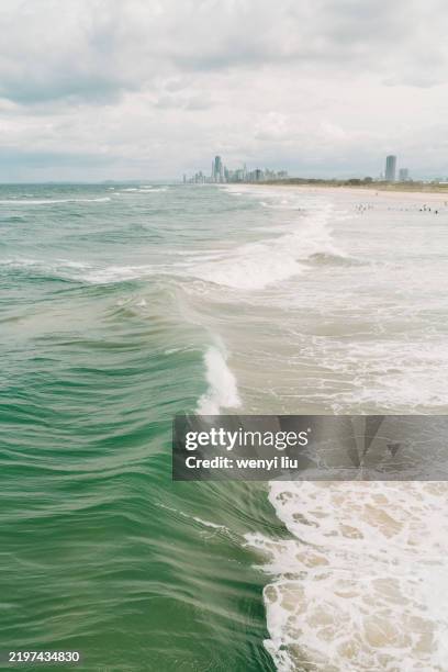 people in great waves and white caps at main beach, gold coast, viewing from sand bypass pumping jetty - main beach gold coast stock pictures, royalty-free photos & images
