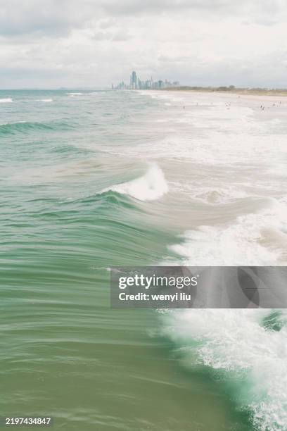 people in great waves and white caps at main beach, gold coast, viewing from sand bypass pumping jetty - main beach gold coast stock pictures, royalty-free photos & images
