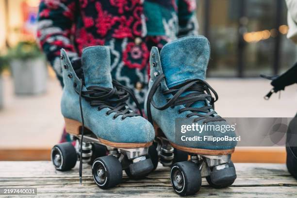 blue suede roller skates standing on a wooden bench, ready for skating - blue suede shoes for women stock pictures, royalty-free photos & images
