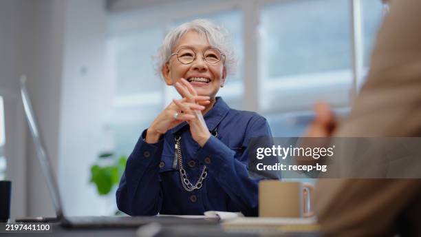 senior-geschäftsfrau, die geschäftsmann finanziell berät - arbeitende rentner stock-fotos und bilder