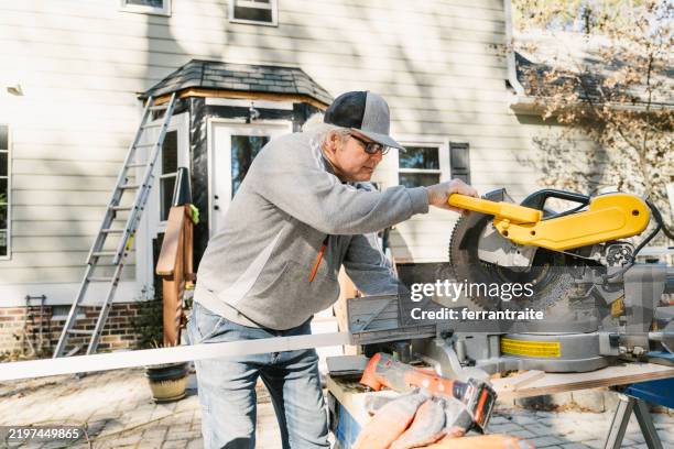 bauarbeiter bei der reparatur einer hausverkleidung - kreissäge stock-fotos und bilder