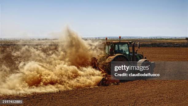 ploughing with a tractor - aratro foto e immagini stock