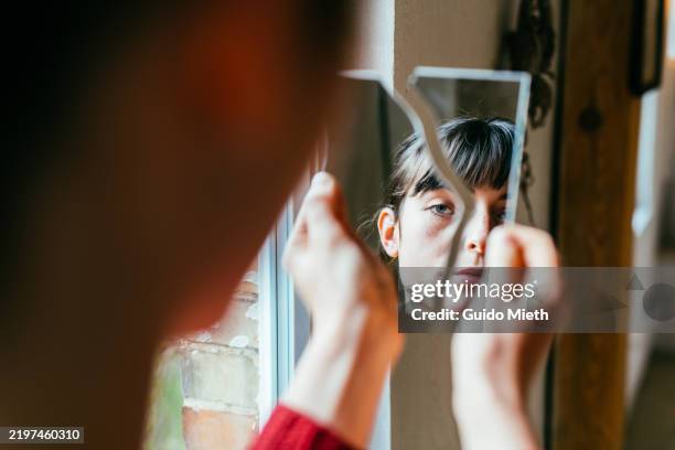 portrait of a beautiful woman looking into a broken mirror. - enfermedad mental fotografías e imágenes de stock