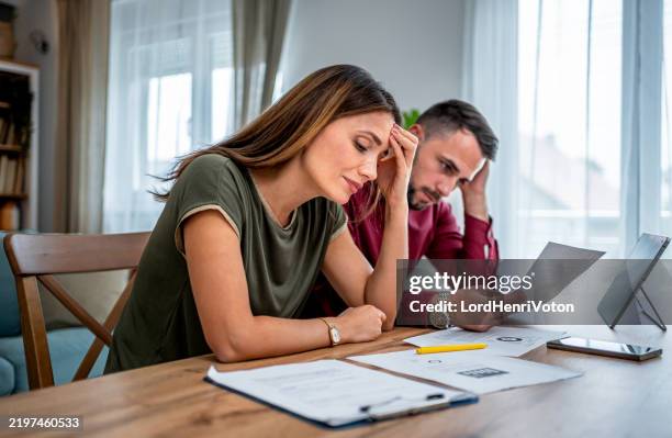 worried young couple manages home finances - bankruptcy stock pictures, royalty-free photos & images