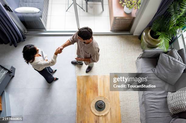 real estate agent greeting a man with a handshake - landlord stock pictures, royalty-free photos & images