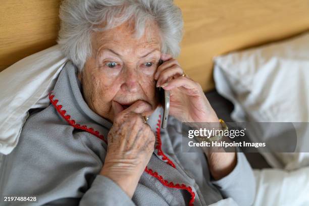 horrified senior woman making phone call. phone scams on elderly people. - shock stock pictures, royalty-free photos & images