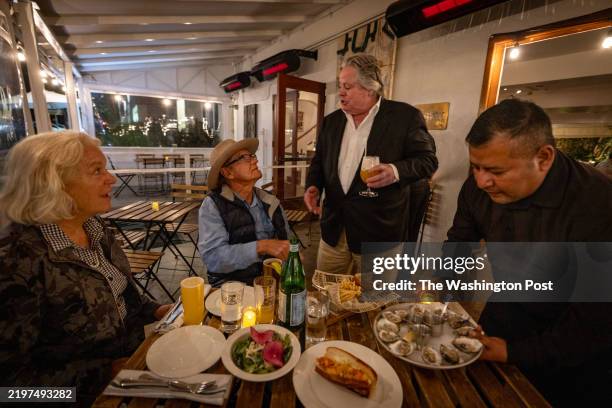 Michael McCarty, owner of Michael's Santa Monica restaurant, speaks to regular customers Pamela Burton, left, and Richard Hertz about the recent fire...