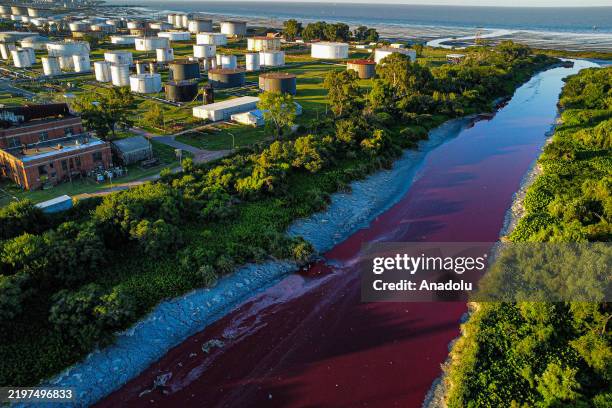 An aerial view of the red river after a suspected chemical spill turned the waters along the Rio de la Plata coastline red, raising environmental...