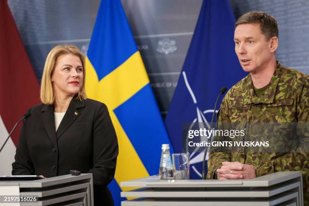 Latvian Prime Minister Evika Silina listens as Kaspars Pudans , Commander of the Latvian National Armed Forces, addresses a joint press conference in...