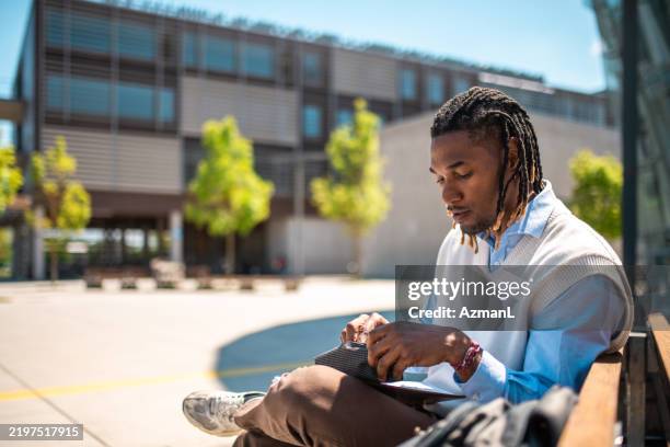 focused black male student engaged in outdoor study - dreadlocks stock pictures, royalty-free photos & images