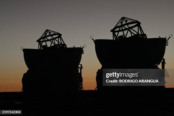 Picture of two of the optical telescopes on the platform of the Very Large Telescope , with consists of four optical telescopes and four movable...