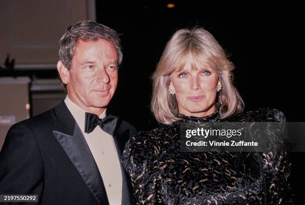 American actress Linda Evans, wearing a black-and-gold outfit, and her partner, American businessman Richard Cohen, who wears a tuxedo and bow tie,...