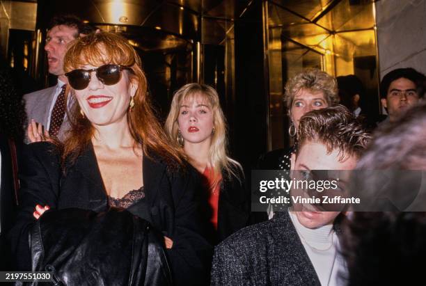 American actress Katey Sagal, wearing a black outfit with a black leather jacket over her arm and sunglasses, American actress Christina Applegate,...