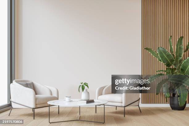 modern interior: a living/waiting room with a couple of cozy armchairs in front of a partly cotton white, partly hardwood paneled accent wall background, large window and decoration - vase stock pictures, royalty-free photos & images