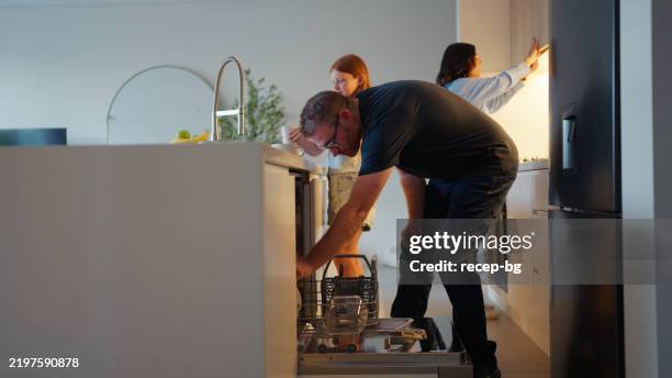 family cleaning up together in the kitchen - dishwasher stock pictures, royalty-free photos & images