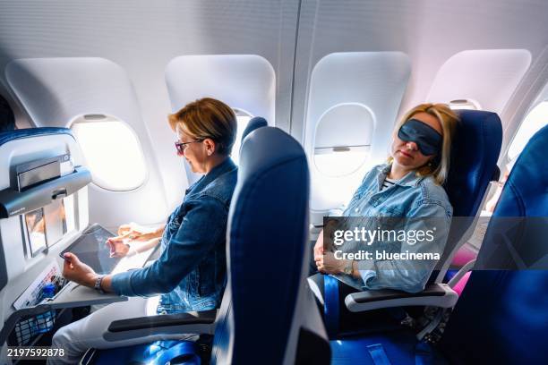 female passenger using a digital tablet during flight - cabine de passageiros imagens e fotografias de stock