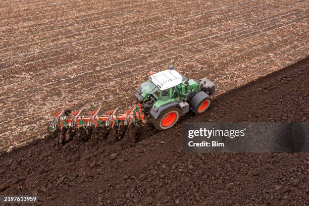 traktor-pflügenfeld - landwirtschaftliche maschine stock-fotos und bilder