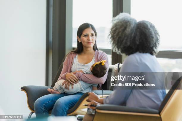 mother and baby in counseling session, healthcare professional listening - postpartum depression stock pictures, royalty-free photos & images