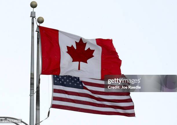 Canadian flag flies next to the American one at the Lewiston-Queenston border crossing bridge on February 04, 2025 in Niagara Falls, Canada. U.S....