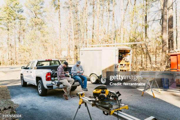 operai edili seduti sul portellone posteriore durante la pausa pranzo - furgone pickup foto e immagini stock