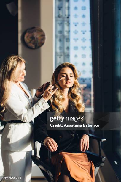 makeup artist in the process of creating makeup in a beauty salon - maquillage professionnel photos et images de collection