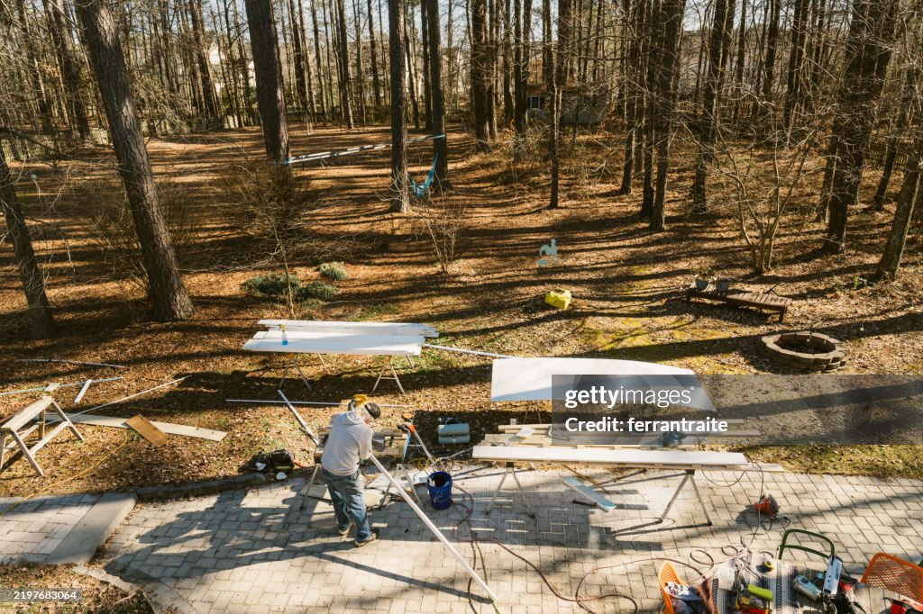 Construction workers repairing the siding of a house