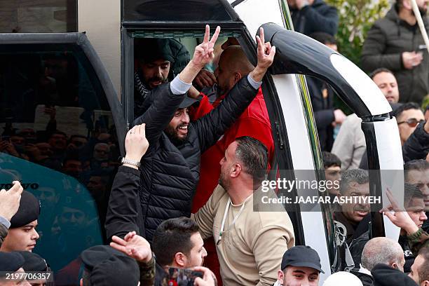 Former Palestinian prisoner released by Israel flashes the victory sign as he leaves a bus in the occupied West Bank city of Ramallah on February 8...