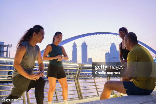 multiracial friends prepping up at promenade for early morning jog in the city - warm up exercise stock pictures, royalty-free photos & images