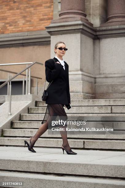 Justyna Czerniak wears black tule skirt, white shirt, black jacket, black tights and blakc Chanel mini bag outside the MKDT fashion show during the...