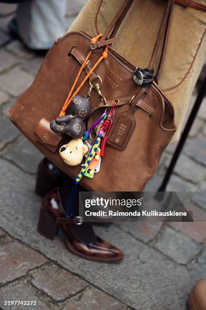 Janka Polliani wears brown cowboy shoes, brown skirt and a brown leather bag with bag charms or accessories outside the Garment fashion show during...