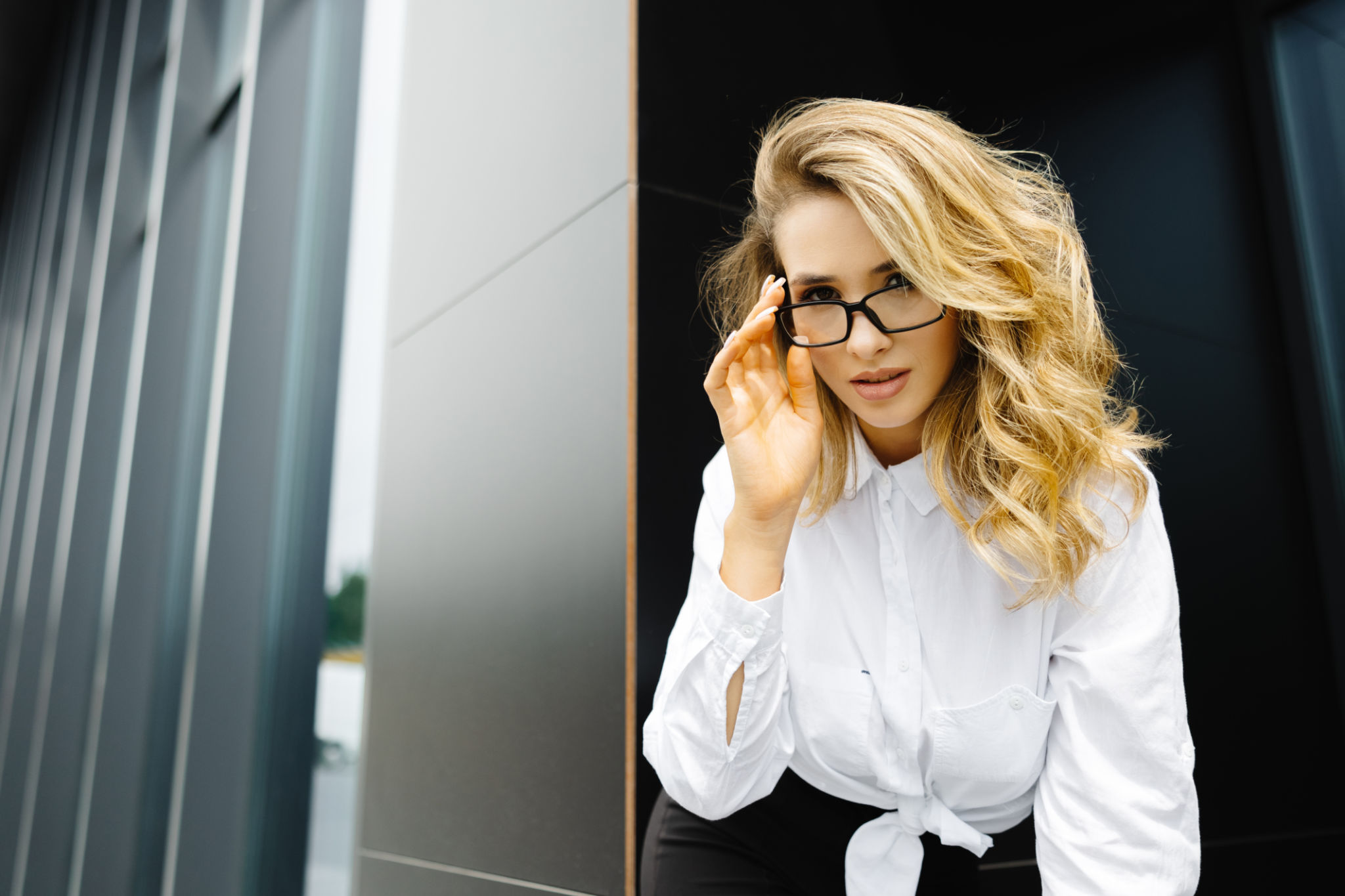 Businesswoman is standing at the corporate building. Confident caucasian woman in glasses is looking to the camera Businesswoman is standing at the corporate building. Confident caucasian woman in glasses is looking to the camera