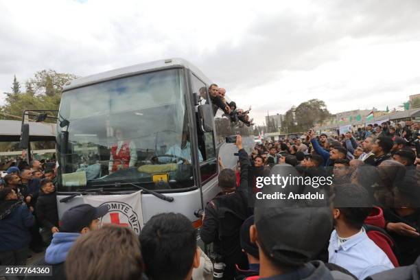 Palestinians greet Red Cross bus, carrying prisoners released in the 5th round of the ceasefire and prisoner swap agreement between Hamas and Israel,...