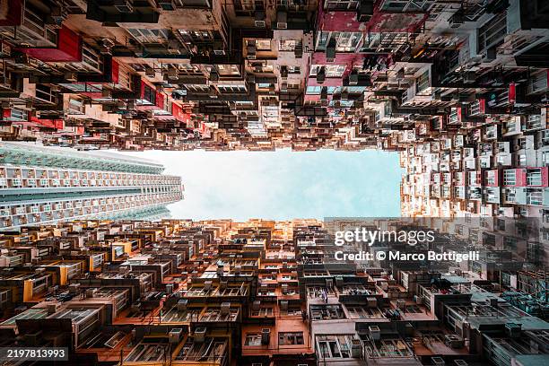 skyward view of urban residential high-rise buildings against a clear blue sky, hong kong - urban exploration stock pictures, royalty-free photos & images