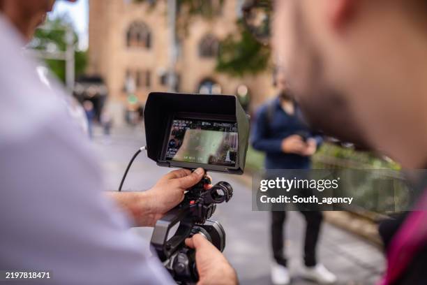 filmmaker capturing footage in sydney's bustling streets during daytime activity - television production stock pictures, royalty-free photos & images