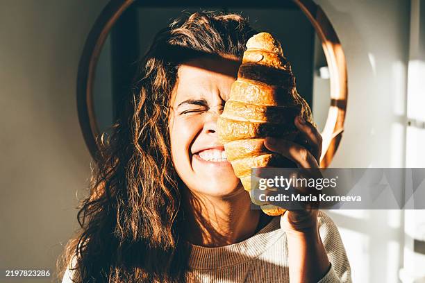 woman holding big fresh croissant. - actividad de fin de semana fotografías e imágenes de stock