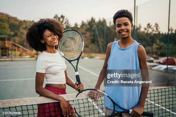 amigos adolescentes dándose la mano en la cancha de tenis - red de tenis fotografías e imágenes de stock